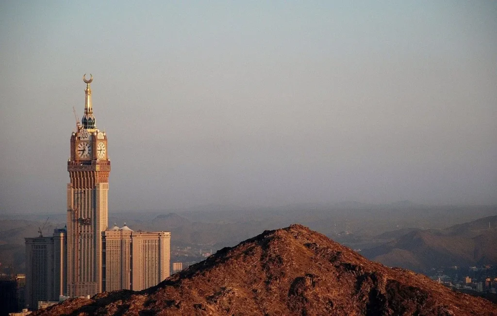 The Makkah clock tower seen over the mountains at golden hour
