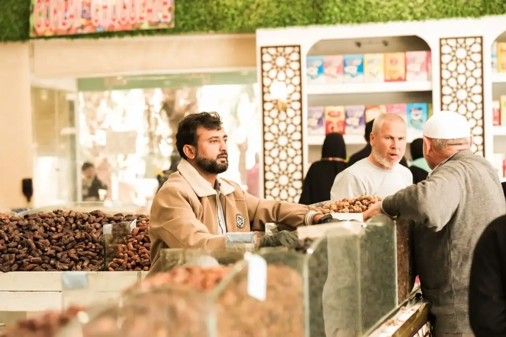 A seller serving customers at a dates shop counter in Saudi Arabia