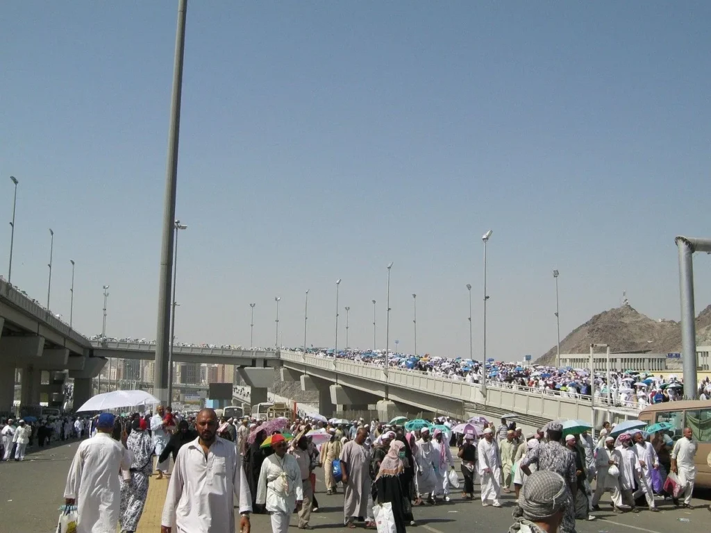 People in ihram walking along a road, seen from a distance