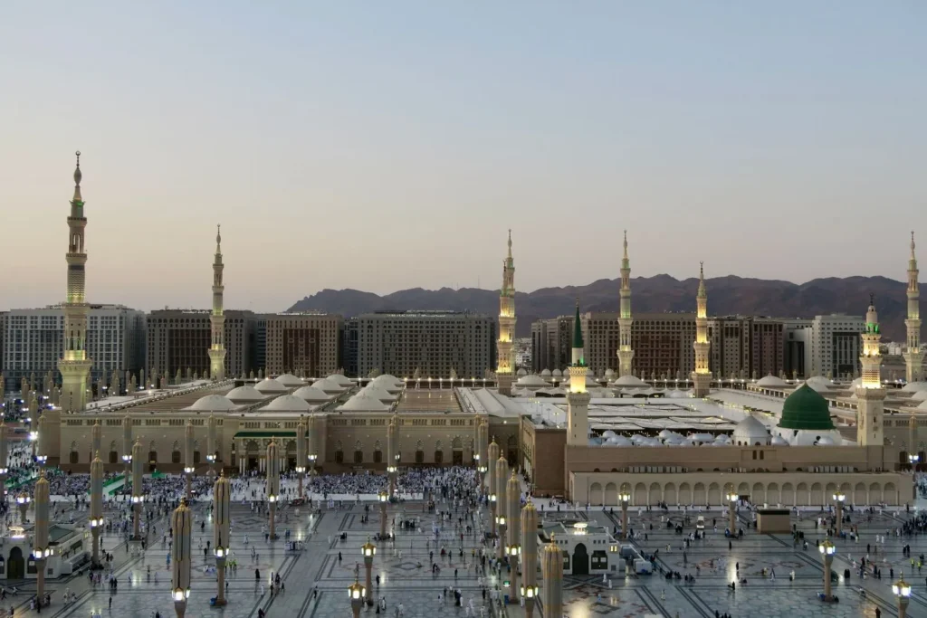 Masjid an-Nabawi in Madinah at dusk with mountains behind