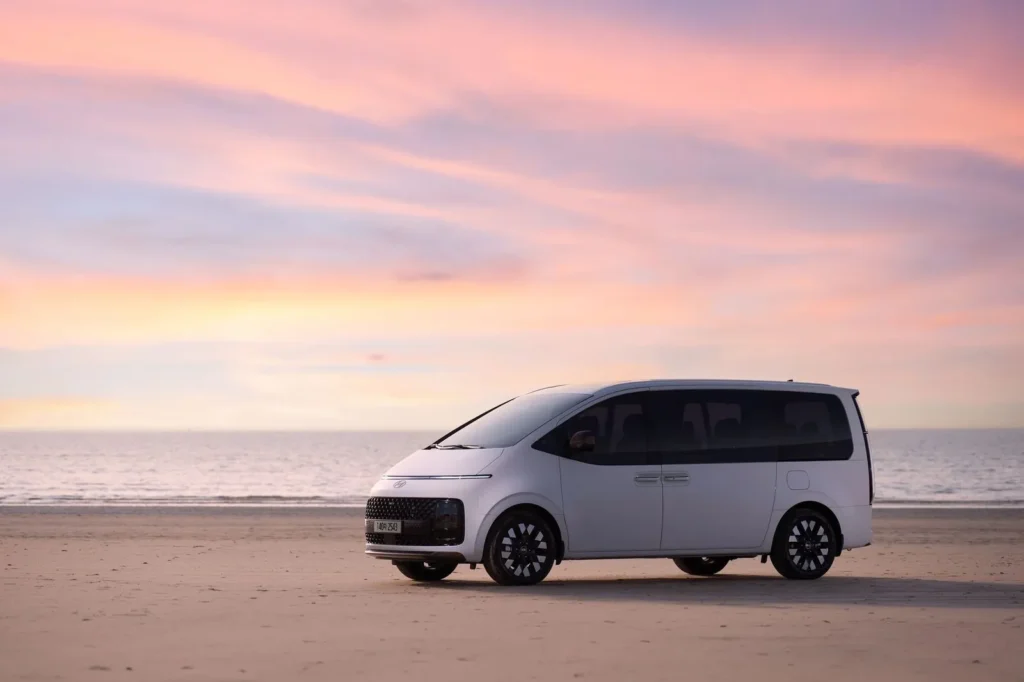 A white Hyundai Staria, side view at sunset