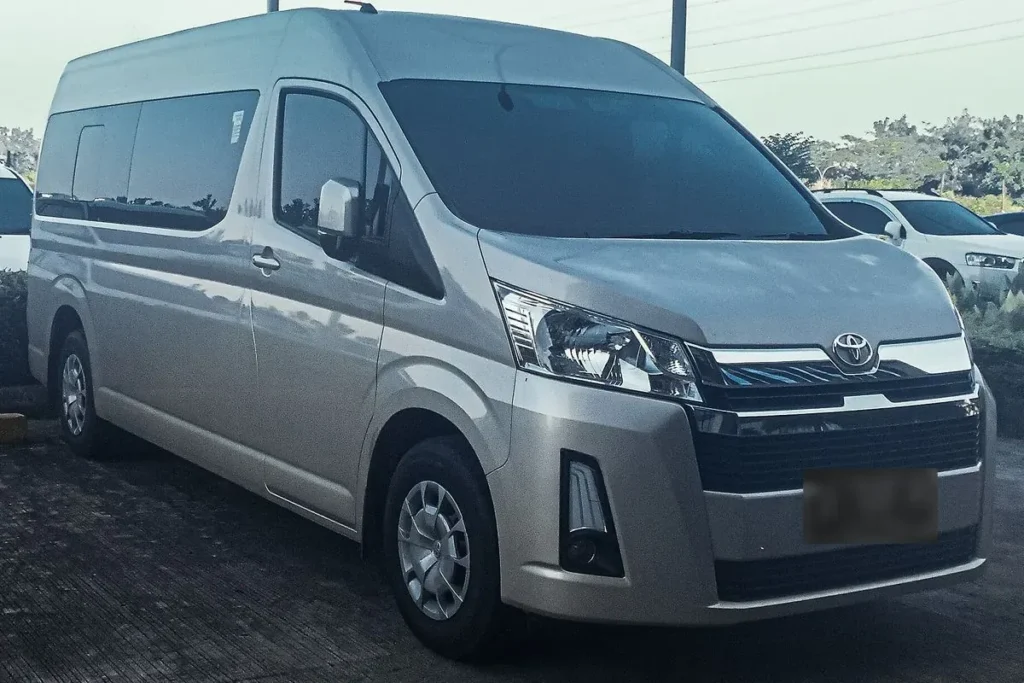 A silver high roof Toyota Hiace, front three quarter view