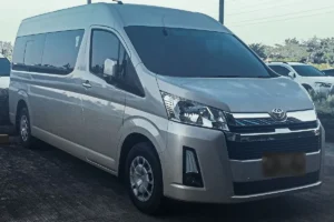 A silver high roof Toyota Hiace, front three quarter view