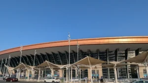 Entrance gates of Terminal 1 at King Abdulaziz International Airport, Jeddah, with its curved copper coloured roof and drop off lane