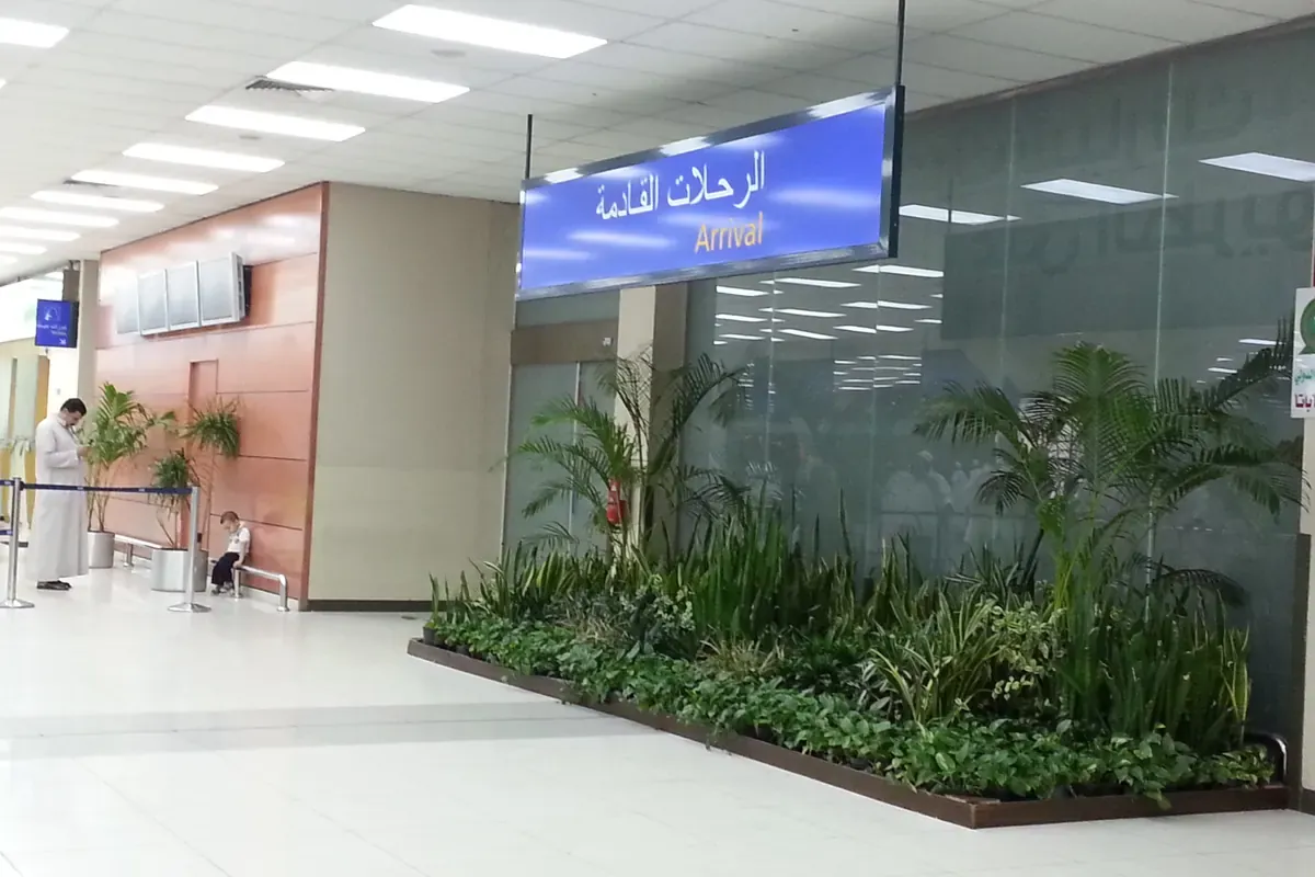 Arrivals hall at King Abdulaziz International Airport, Jeddah, with a blue Arabic and English Arrival sign