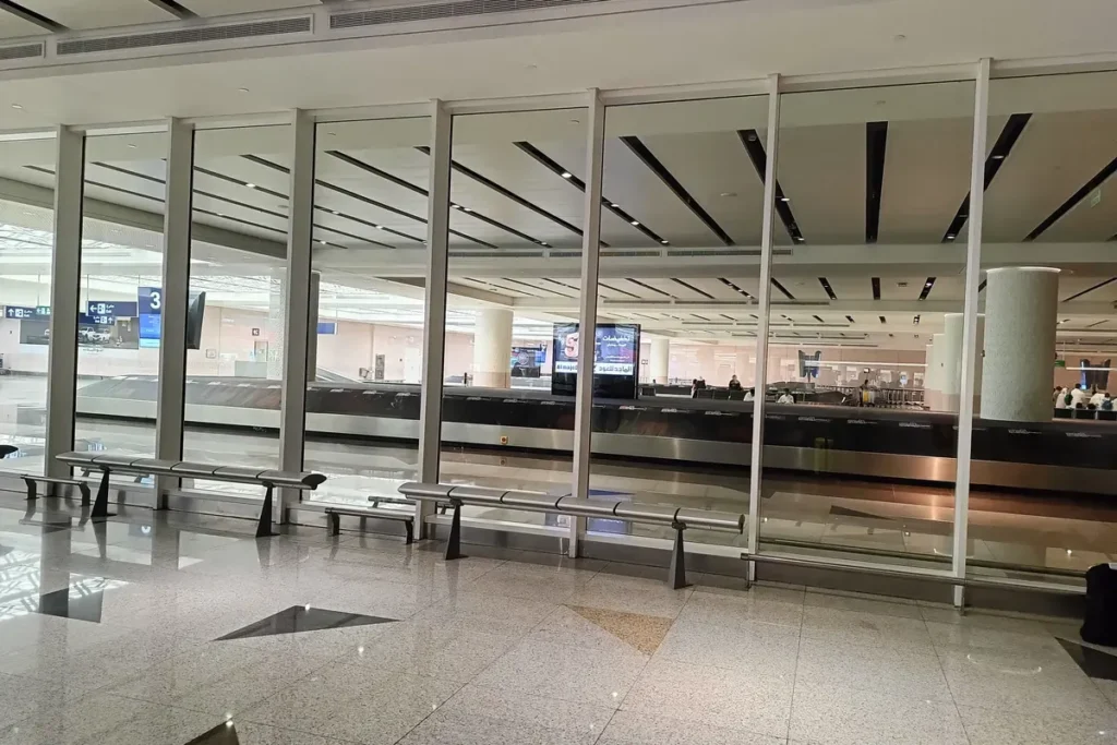 Baggage reclaim hall with carousels and benches at King Abdulaziz International Airport, Jeddah (2023)