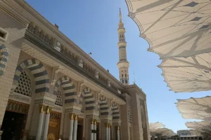 Outer wall, arches and a minaret of Masjid an-Nabawi, Madinah, with the courtyard umbrellas open