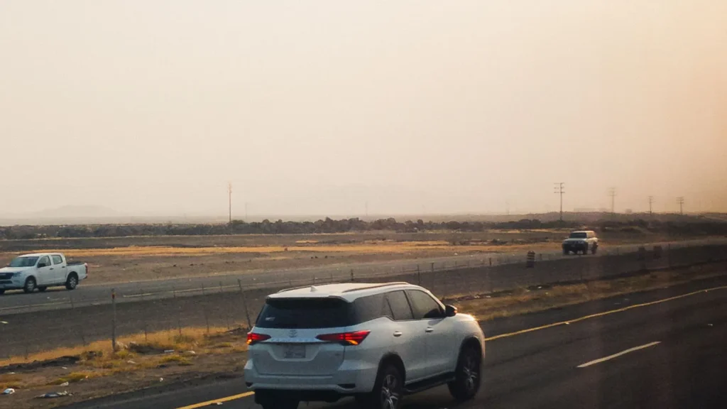 White SUV on a desert highway in Saudi Arabia at dusk