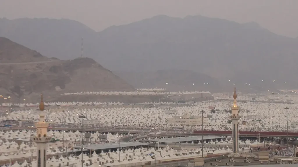 Mina tent city and two minarets with mountains behind, near Makkah