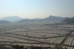Plain of Mina covered in white tents, seen from a mountainside