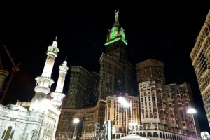 Masjid al-Haram minarets and the Makkah Clock Royal Tower at night, from the street outside the mosque