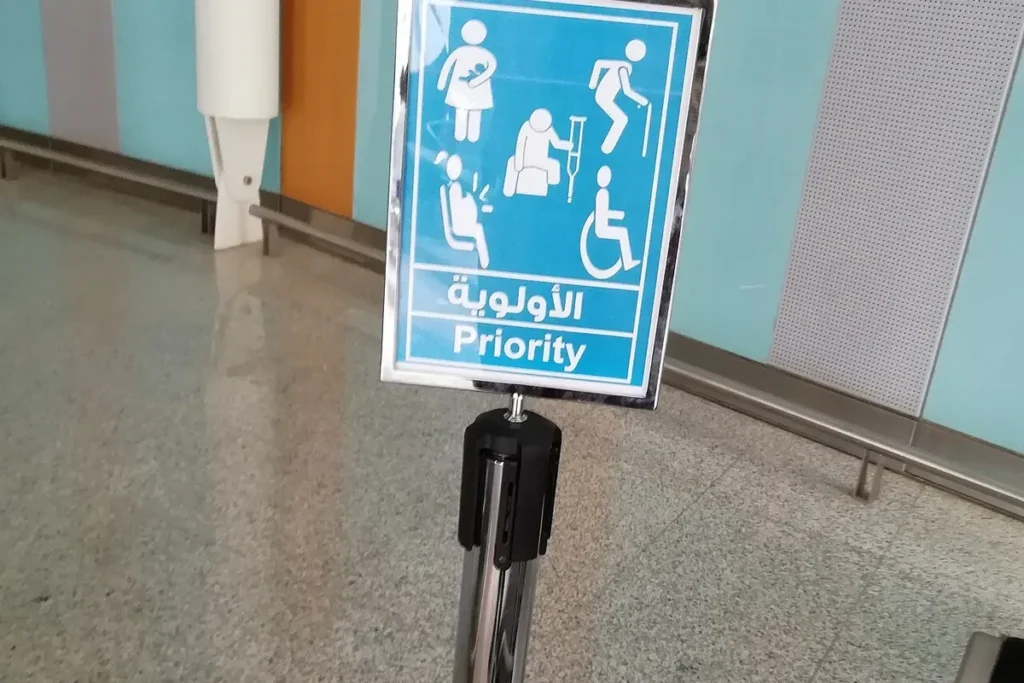Priority sign for elderly, disabled and pregnant travellers and parents with babies, in Arabic and English, at Madinah airport