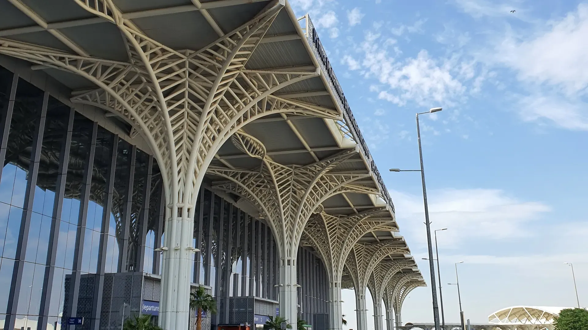 Kerbside entrance of Prince Mohammad bin Abdulaziz International Airport, Madinah, under its white tree shaped canopy columns