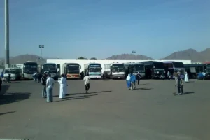 Coaches lined up in the car park of the new terminal at Prince Mohammad bin Abdulaziz Airport, Madinah, with mountains behind