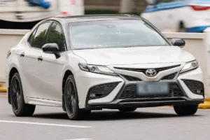 Toyota Camry XV70 facelift, white, front three quarter view.