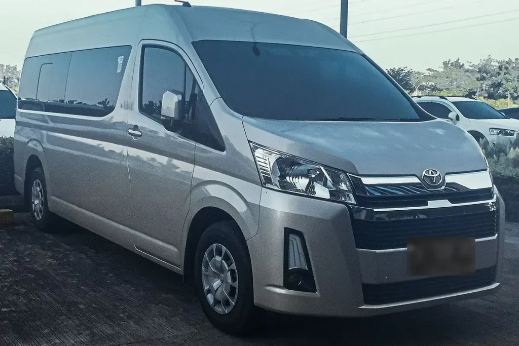 Toyota HiAce H300 (current generation) high roof, silver, front three quarter view.