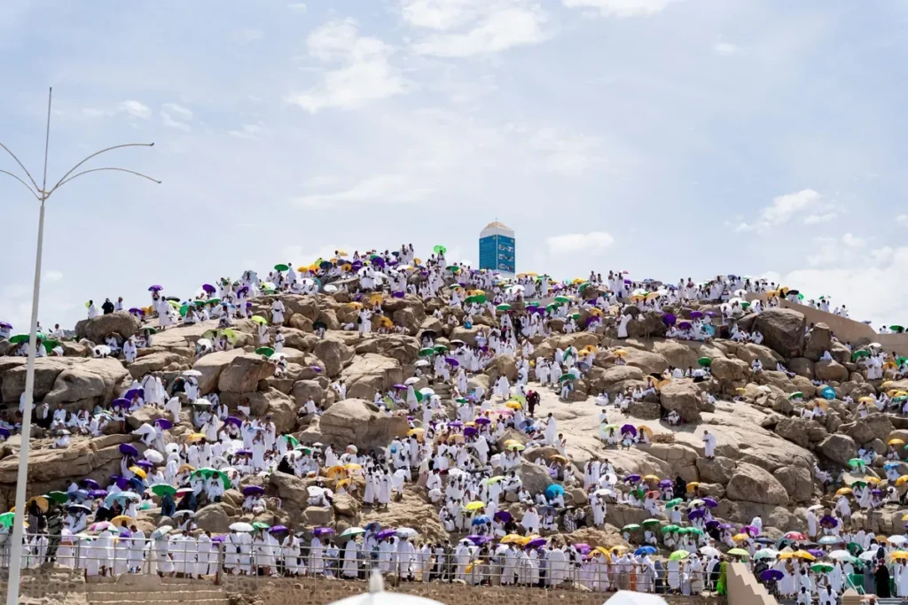Jabal al-Rahmah at Arafat covered in pilgrims in white with umbrellas