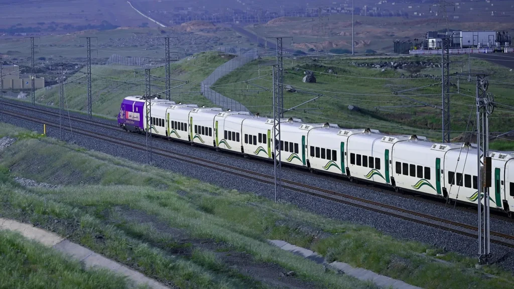 Haramain High Speed Railway train running through green hills in the Hijaz
