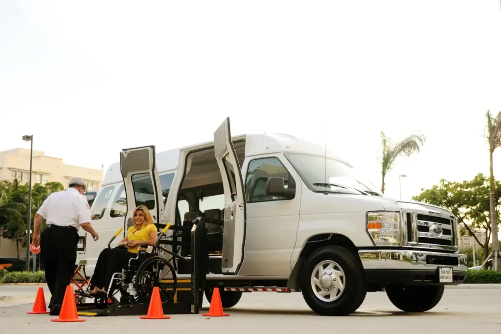 Driver helping a wheelchair user onto a van lift; generic, location not stated