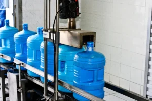 Large blue bottles being filled on a Zamzam water bottling line