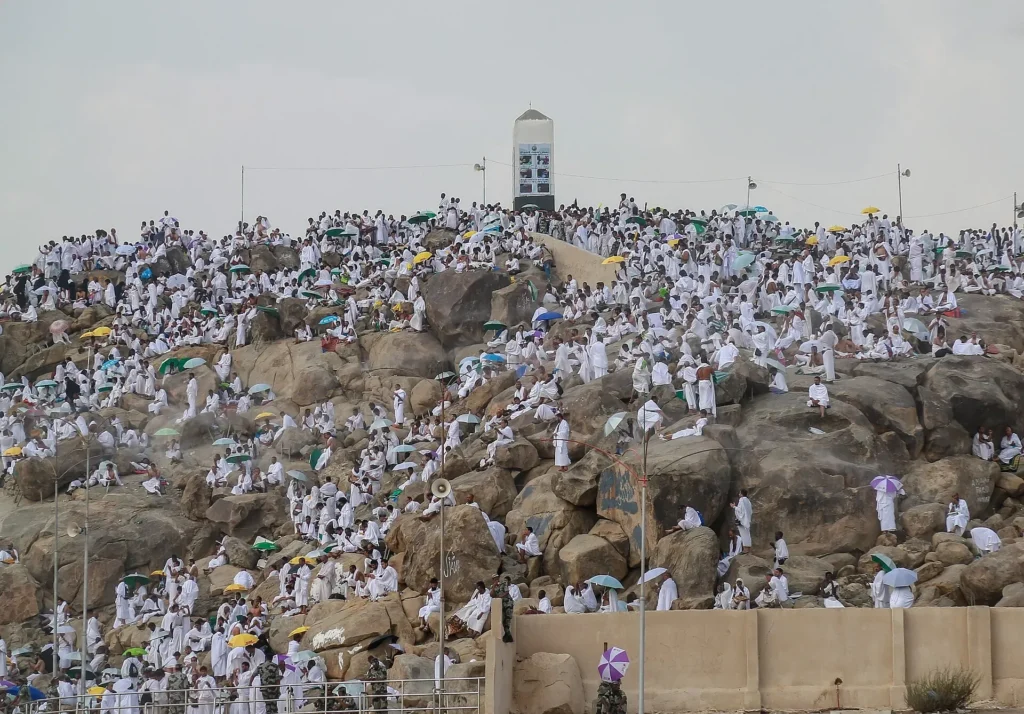 Jabal al-Rahmah at Arafat covered with pilgrims in white, the white pillar on the summit
