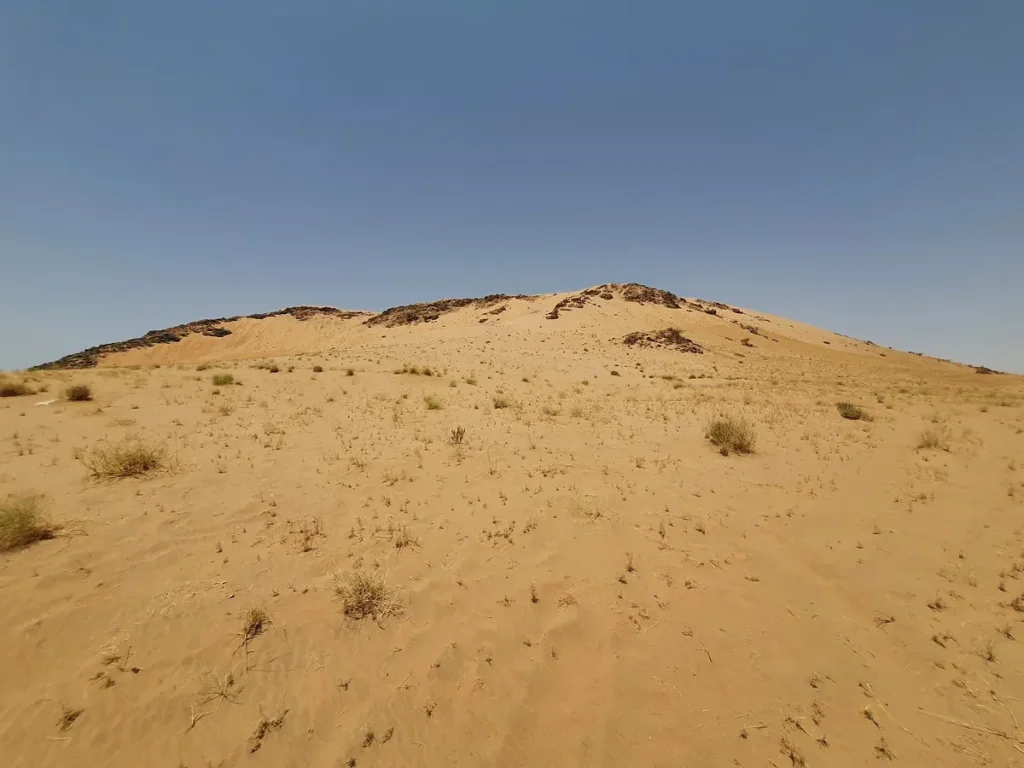 The sand covered slope of Jabal al-Malaikah at Badr under a clear sky