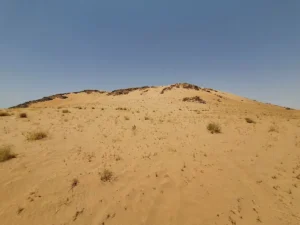 The sand covered slope of Jabal al-Malaikah at Badr under a clear sky