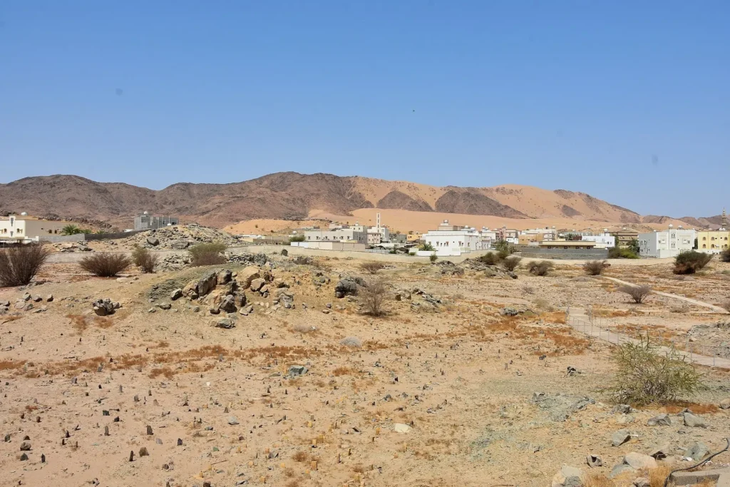 The plain of Badr where the battle was fought, with the low walled burial ground of the martyrs and the hills beyond