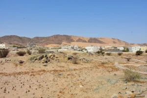 The plain of Badr where the battle was fought, with the low walled burial ground of the martyrs and the hills beyond