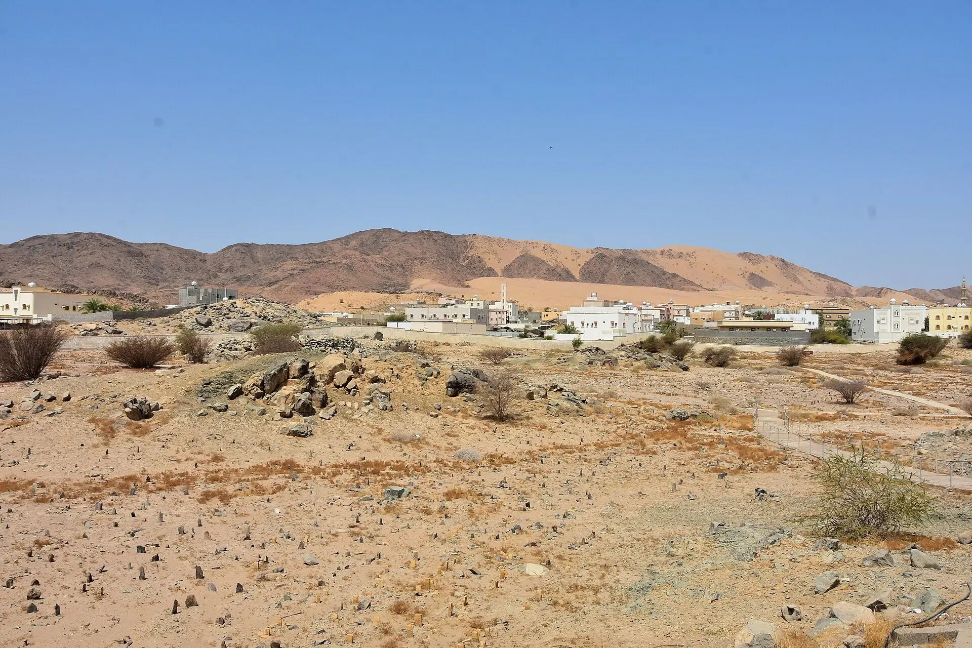 The plain of Badr where the battle was fought, with the low walled burial ground of the martyrs and the hills beyond