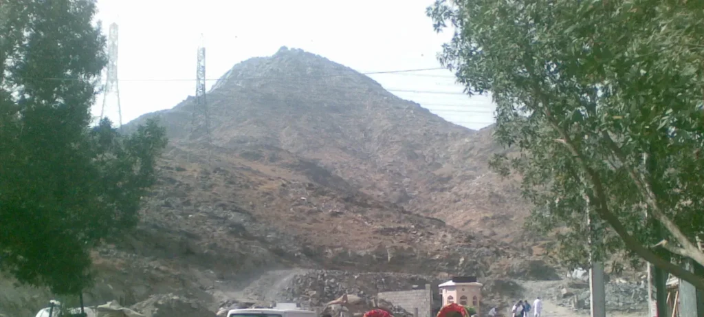 The peak of Jabal Thawr in south Makkah seen from the lane at its foot, framed by trees