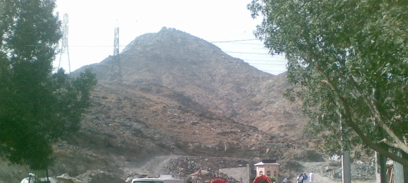 The peak of Jabal Thawr in south Makkah seen from the lane at its foot, framed by trees