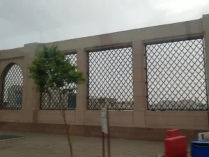 The outer wall of Jannat al-Baqi with its tall grilled windows, seen from the street