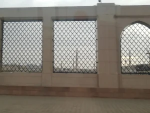 The arched wall and grilles that enclose Jannat al-Baqi