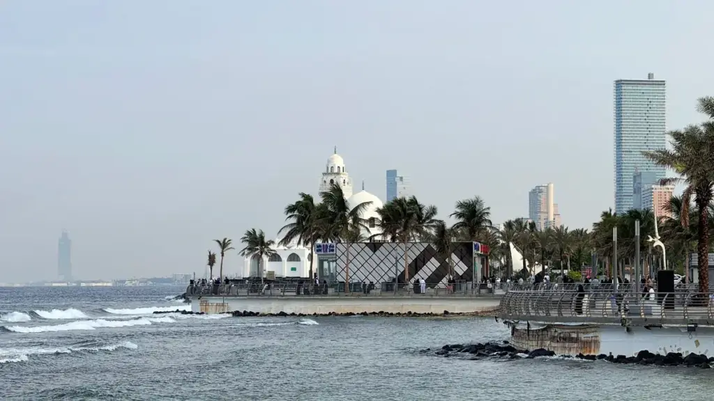 Waves on the Jeddah Corniche with the seafront mosque and towers behind