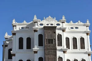 The carved white front and wooden mashrabiya of Shubra Palace in Taif