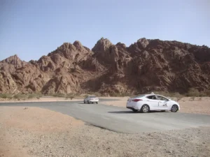 The road through Wadi al-Jinn with jagged dark mountains behind