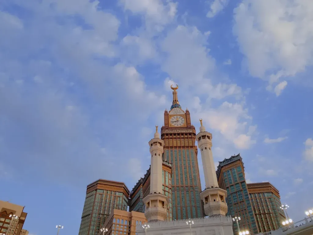 The Abraj al-Bait clock tower in Makkah under a blue sky with clouds