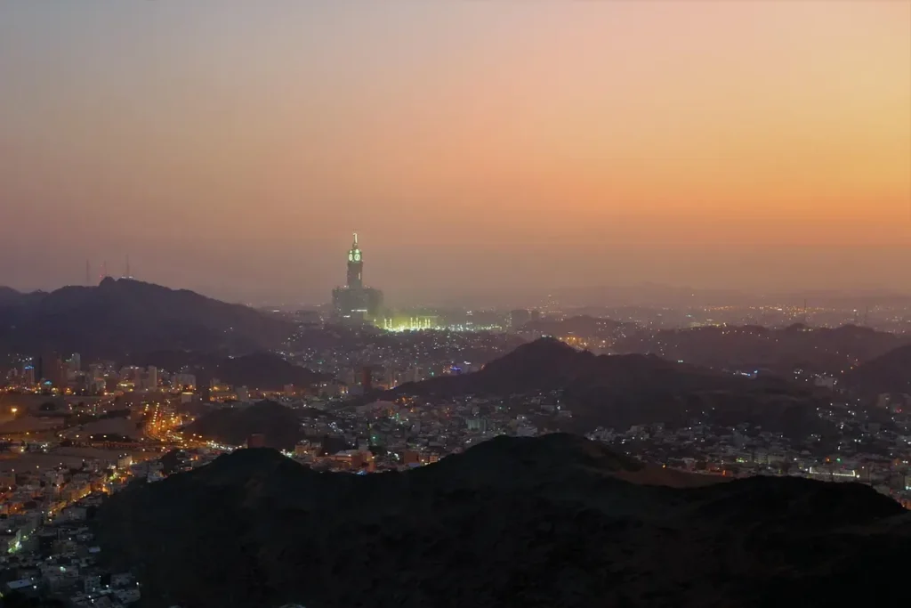مكة عند الغسق من التلال المحيطة، وبرج الساعة مضاء في البعيد