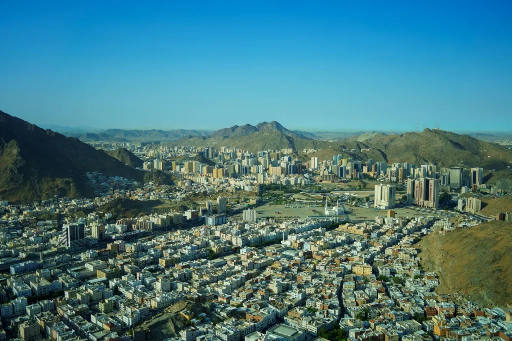 Makkah from the air, the city spread between rocky mountains under a clear sky