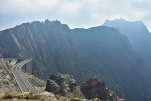 The divided Al Hada highway curving below sheer granite cliffs