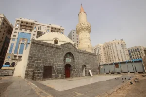 Masjid Abu Bakr near Masjid an-Nabawi, a black stone mosque with a white dome and minaret