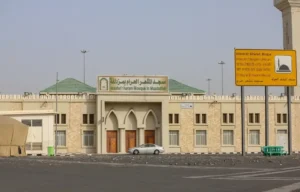 Masjid al-Mashar al-Haram in Muzdalifah, with its name sign and the road in front