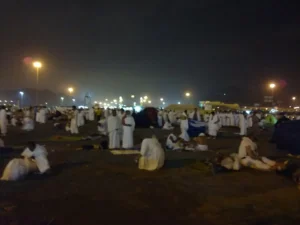 Pilgrims in ihram camped on the ground of Muzdalifah at night after leaving Arafat