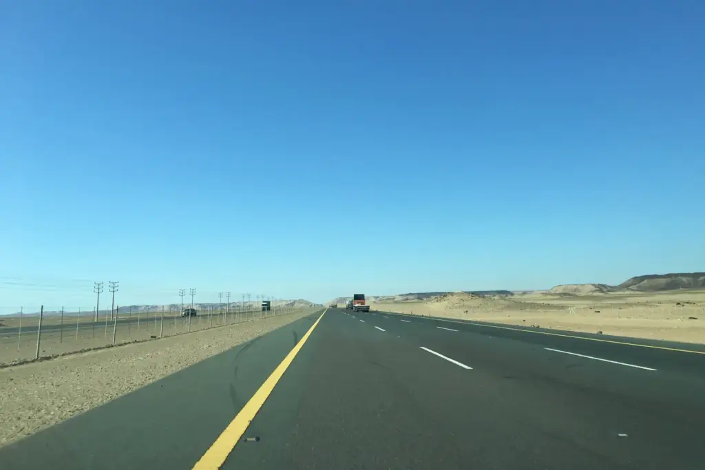 Straight desert highway in Makkah Province under a clear blue sky
